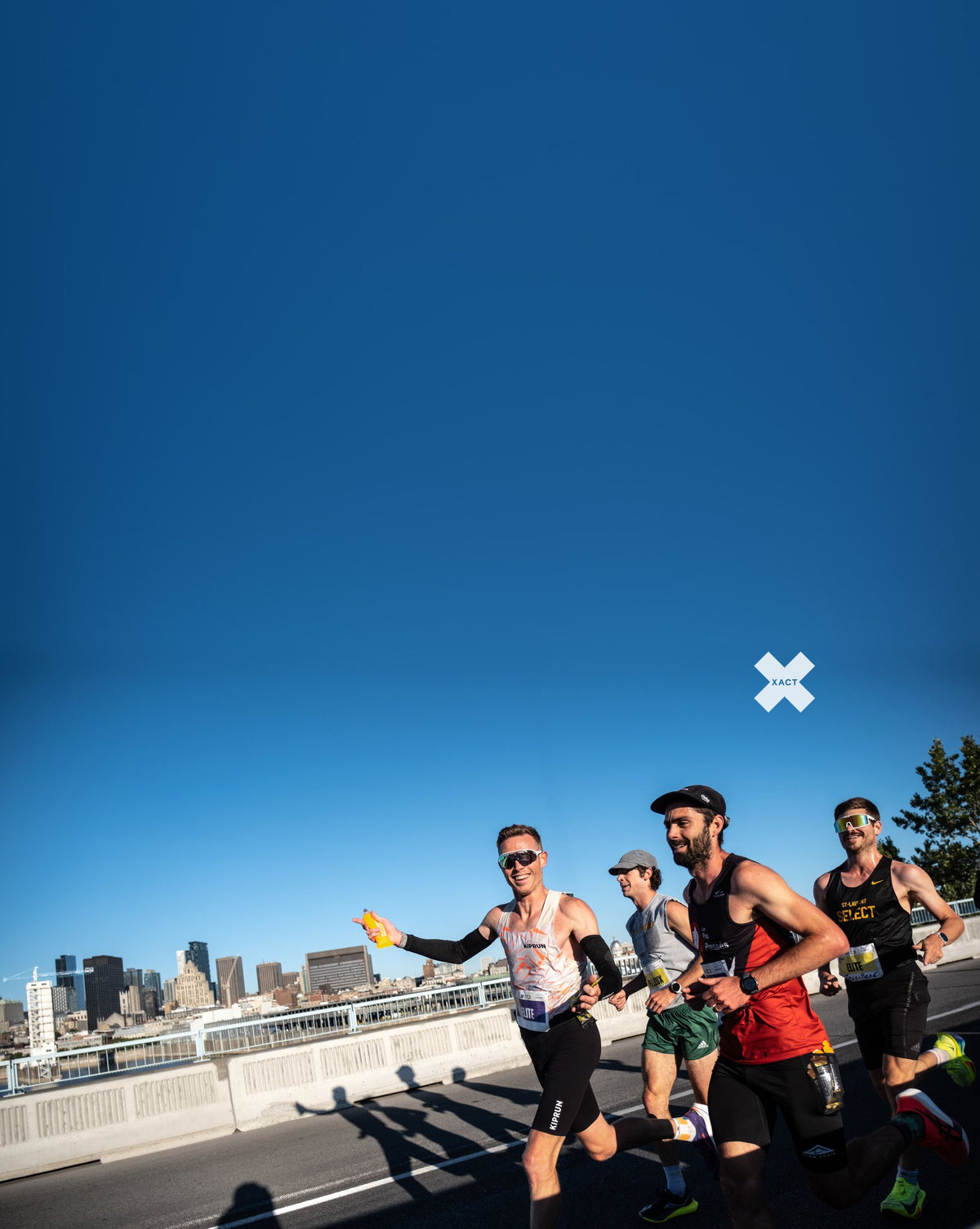 Runners on the Jacques-Cartier Bridge at the Marathon Beneva de Montréal, with the city skyline behind them